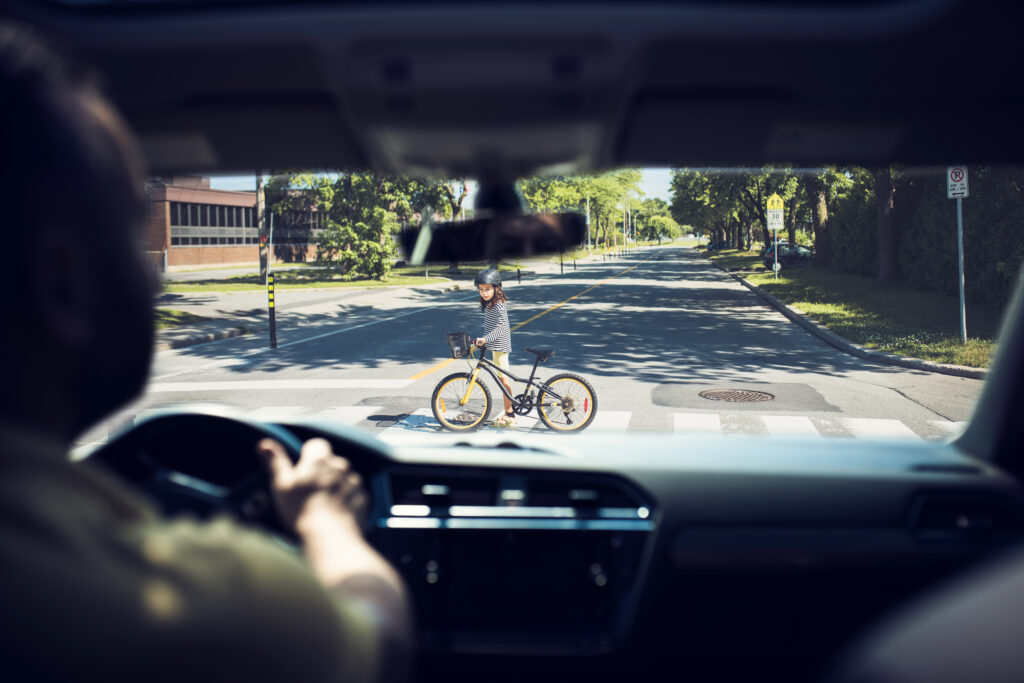 pedestrian crossing the street, car stopping to prevent a pedestrian accident