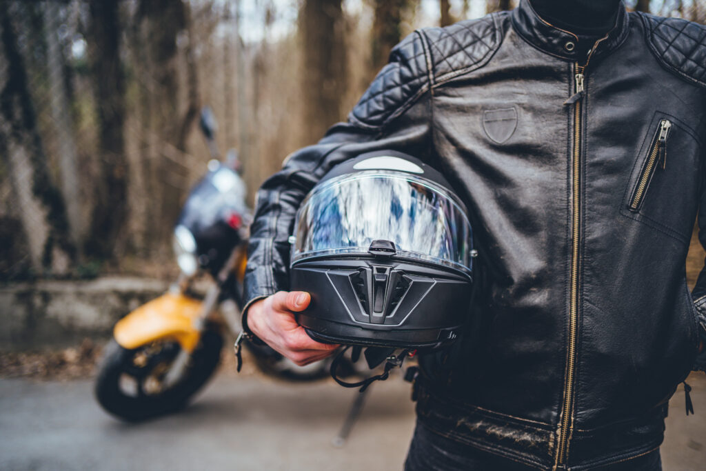 Motorcyclist holding helmet equipment