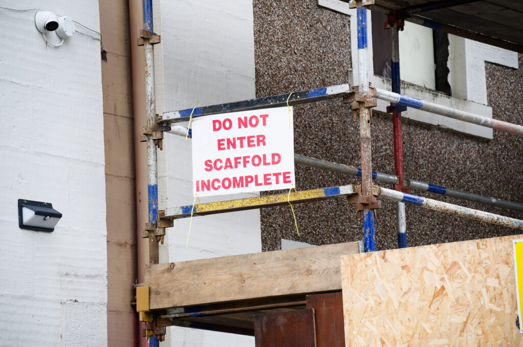 I sign indicates that a scaffolding is incomplete, causing a potential risk to people and animals.