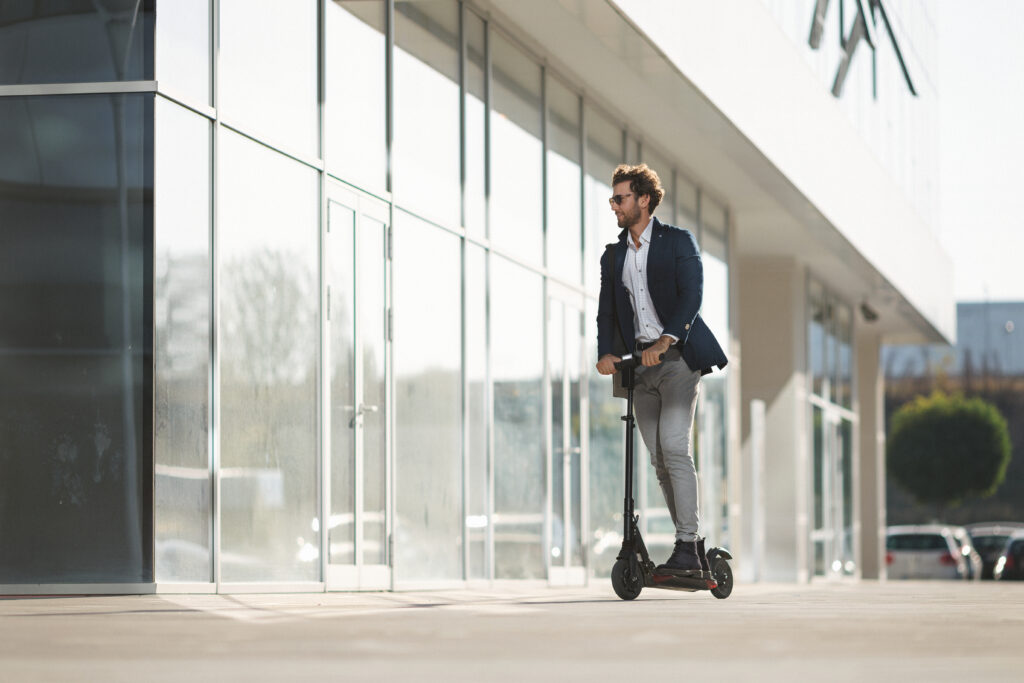 Businessman on e-scooter in the city .