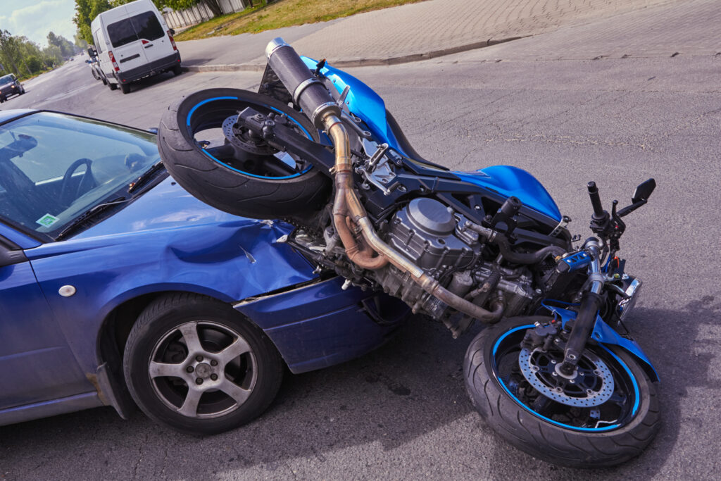 damaged car and motorbike on the city road at the scene of an accident