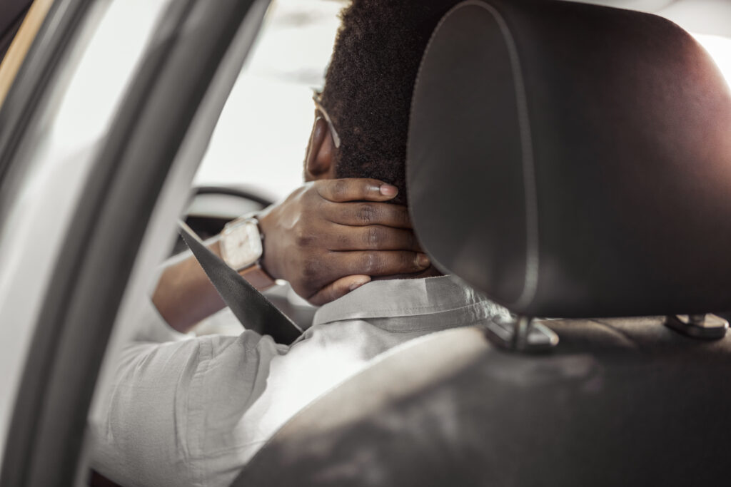 man having neck pain because of a seatbelt defect