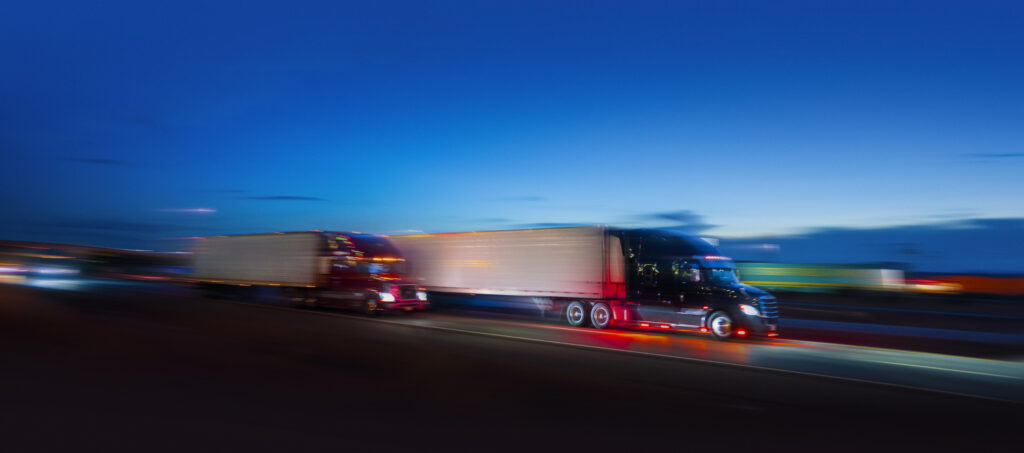 Two semi-truck sdriving on the highway at night - motion blur