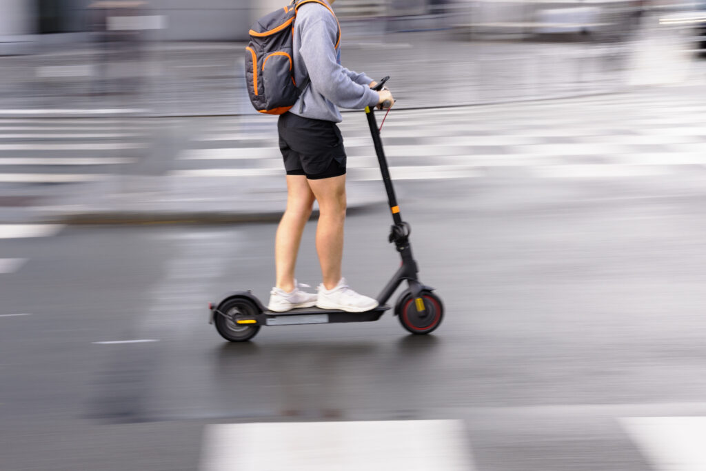 person with an electric scooter on a city street
