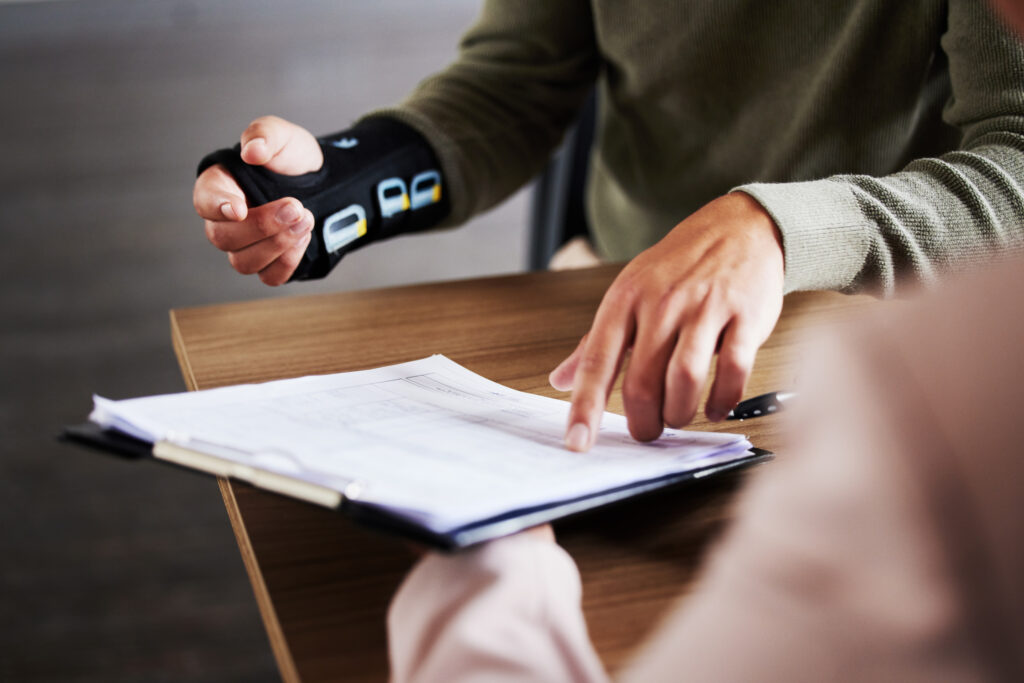 Injury, compensation and man hands with insurance documents, legal contract