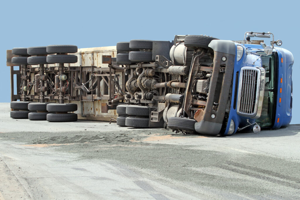 Trucking accident (no serious injuries) resulting in a big rig rolling over on its side.