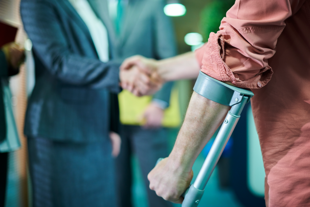 man with a crutch shaking a personal injury lawyers hand