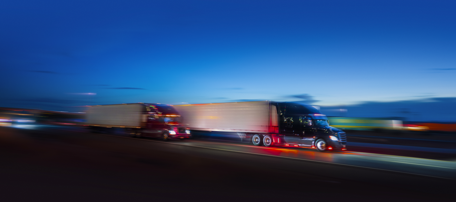 blurry truck driving fast on a highway at night