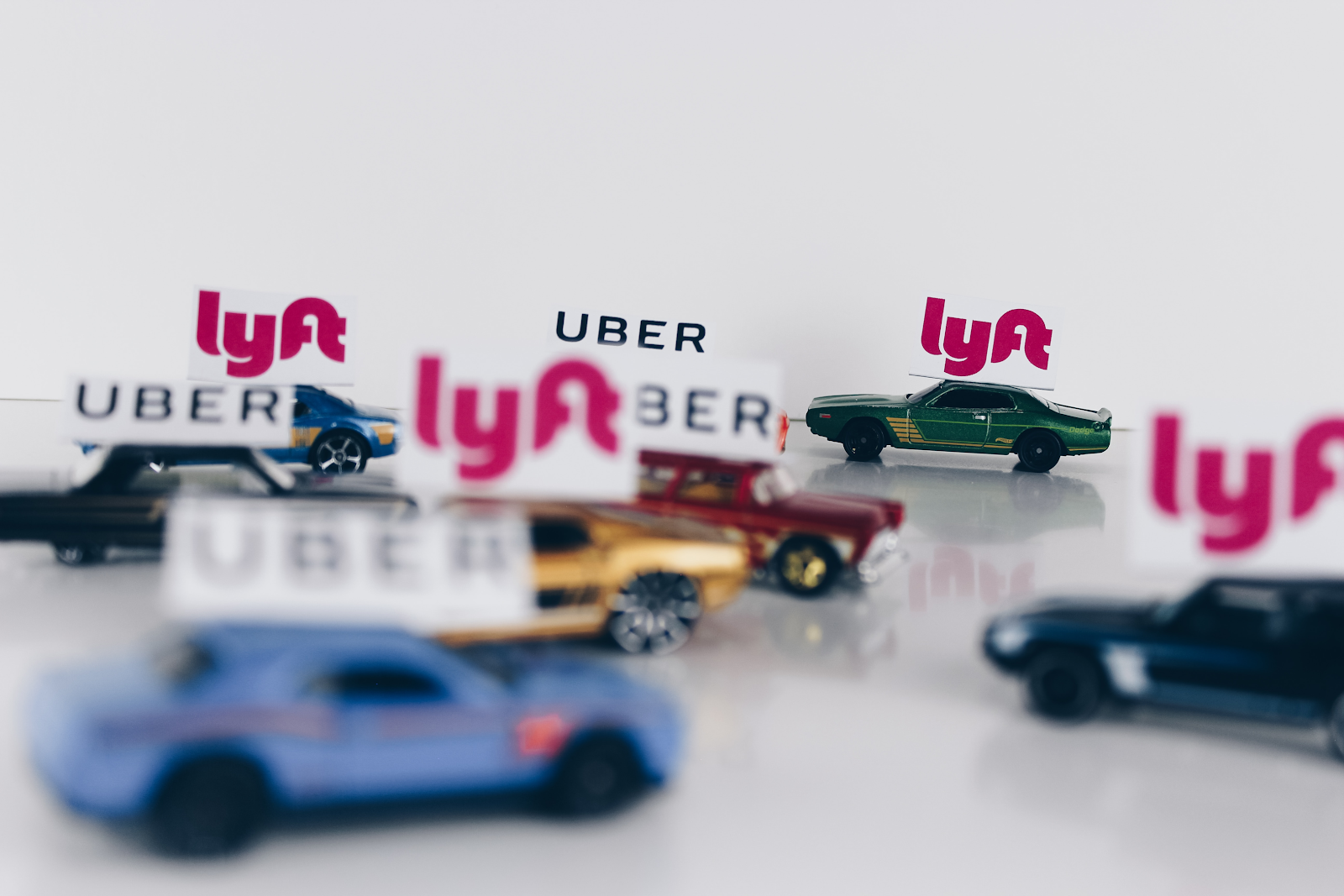 tiny matchbox cars with uber and lyft logos on them