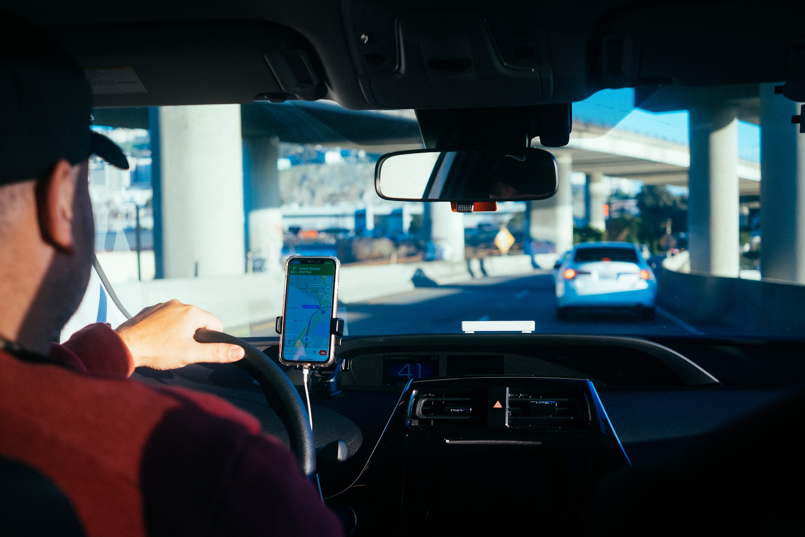 man driving an uber with maps open in the drivers seat