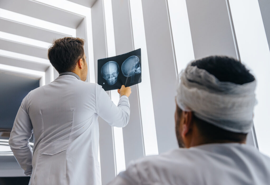 doctor looking at the brain scan of a brain injury patient