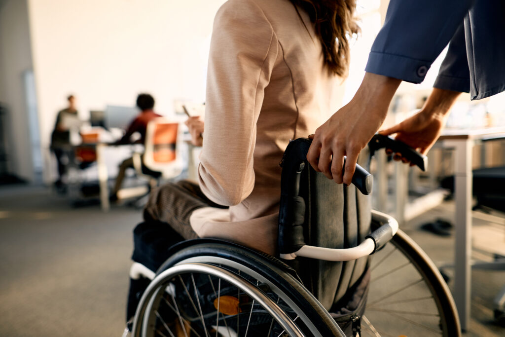 A woman injured in an accident is pushed in a wheelchair to meet with her personal injury attorney