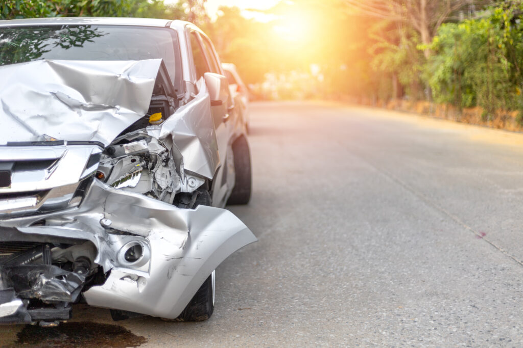 A silver sedan with front-end damage after an accident.